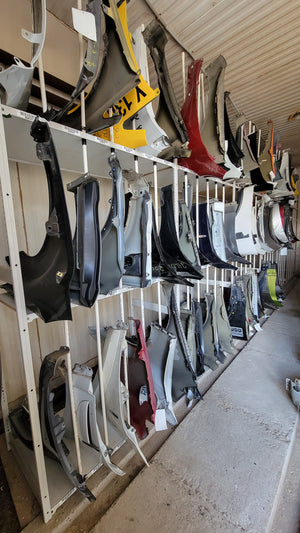 Fenders in a rack at an auto recycler 